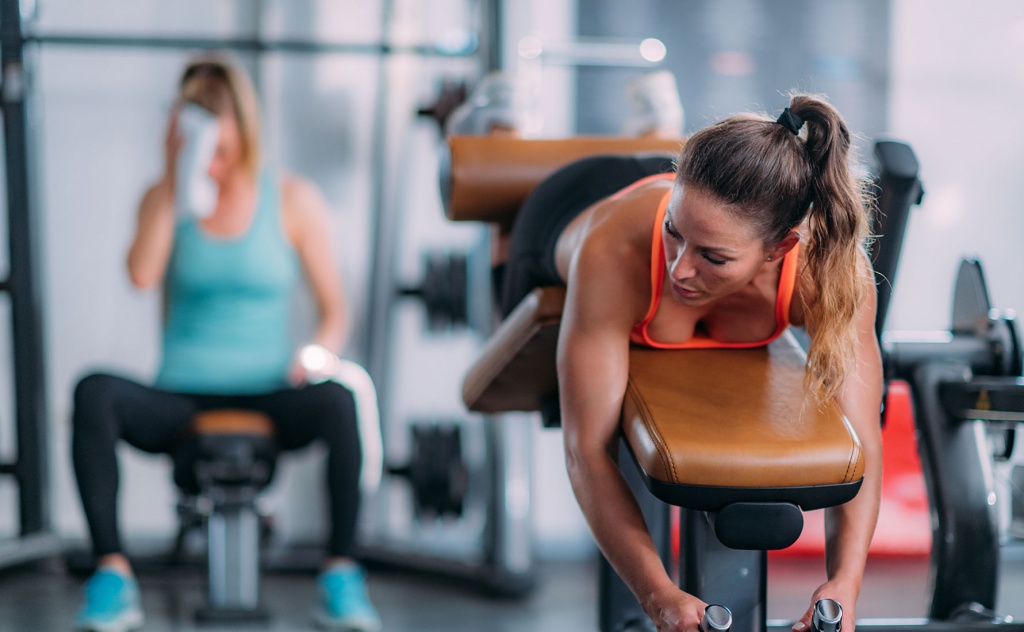 female-athlete-exercising-at-lying-leg-curl-bench--J6LWF6N